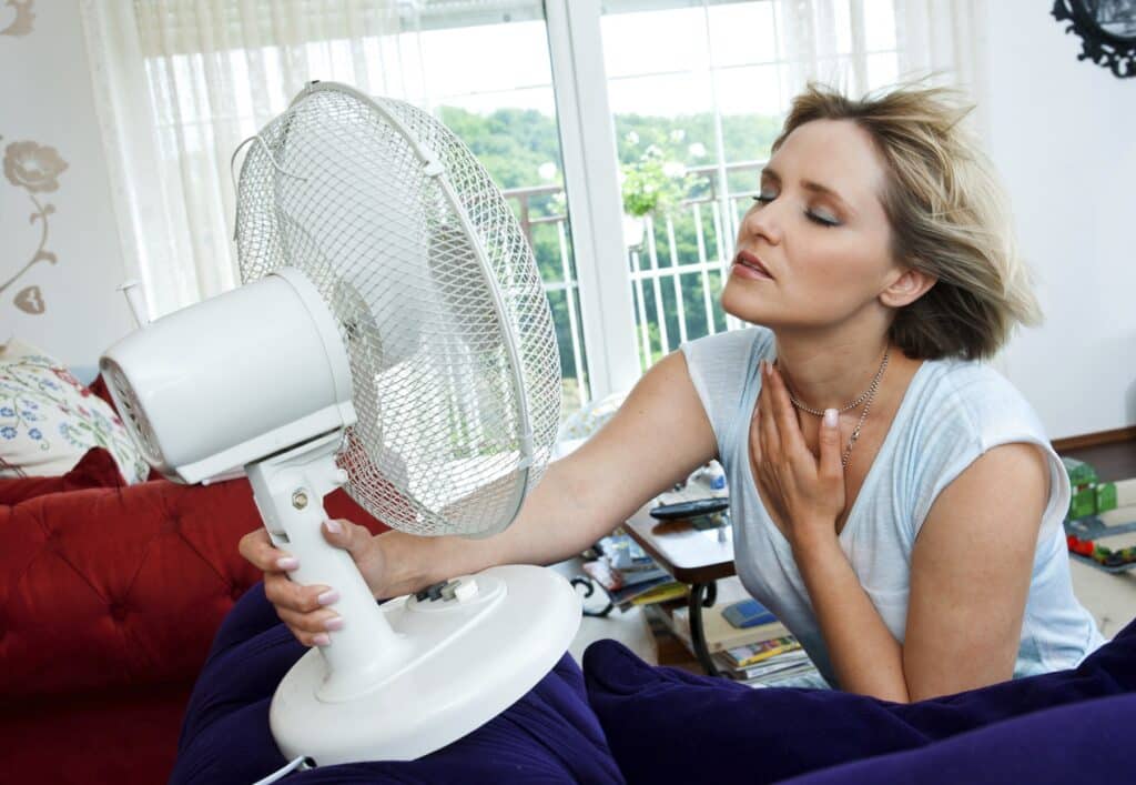 Woman in front of fan on hot day