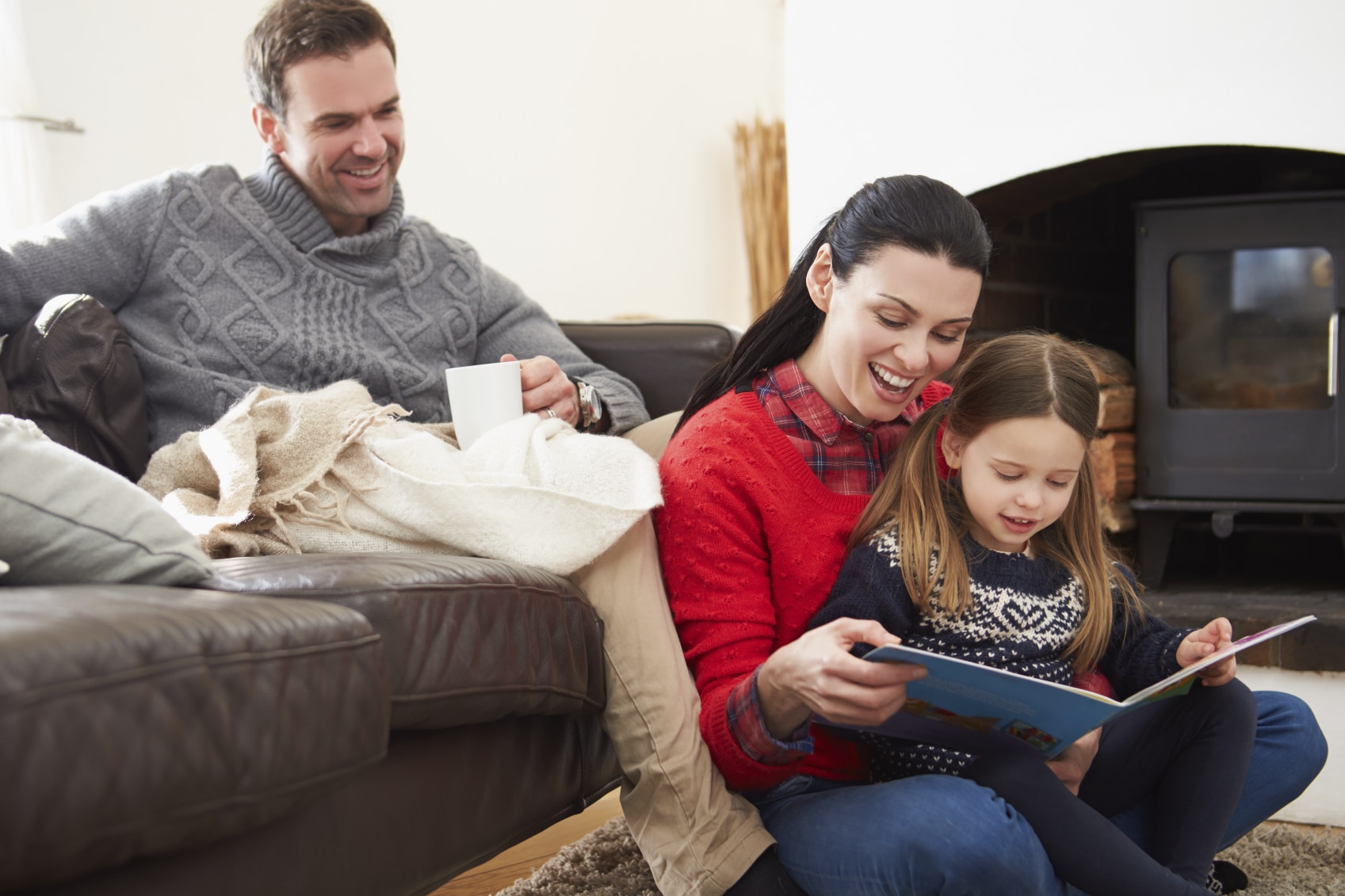 Family relaxing indoors reading a book