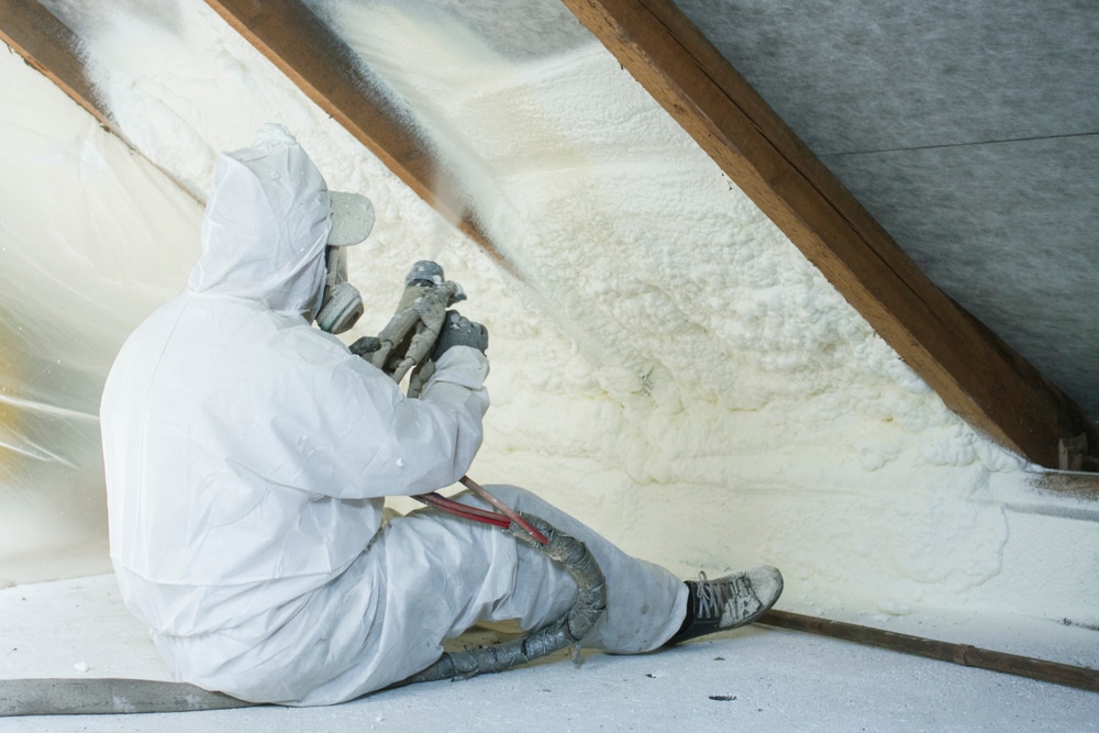 Technician spraying insulation foam