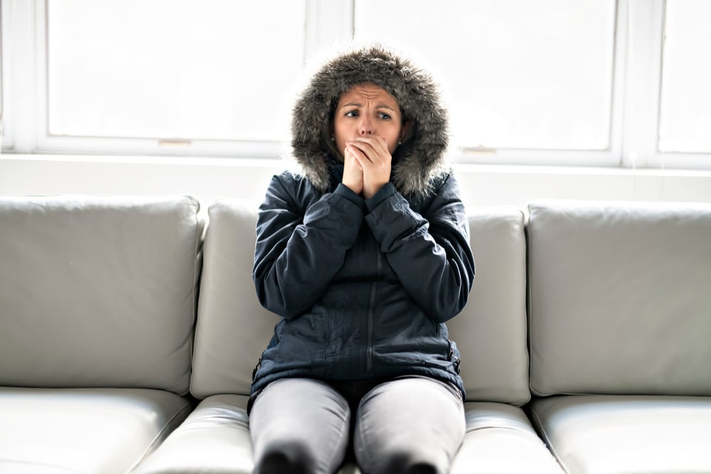 Person wearing coat in chilly home