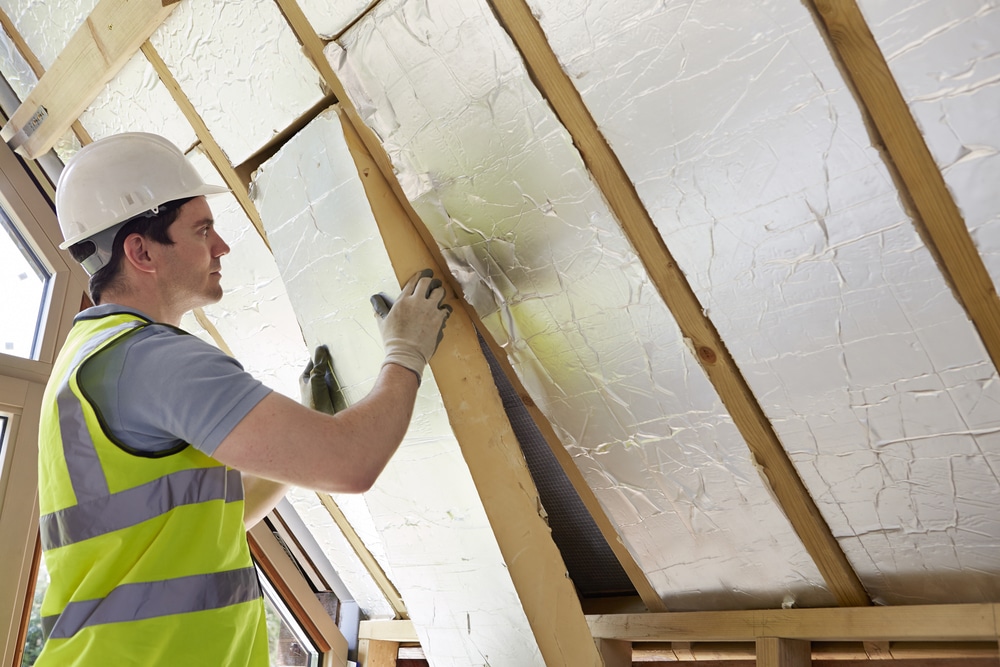 Technician installing sheets of insulation